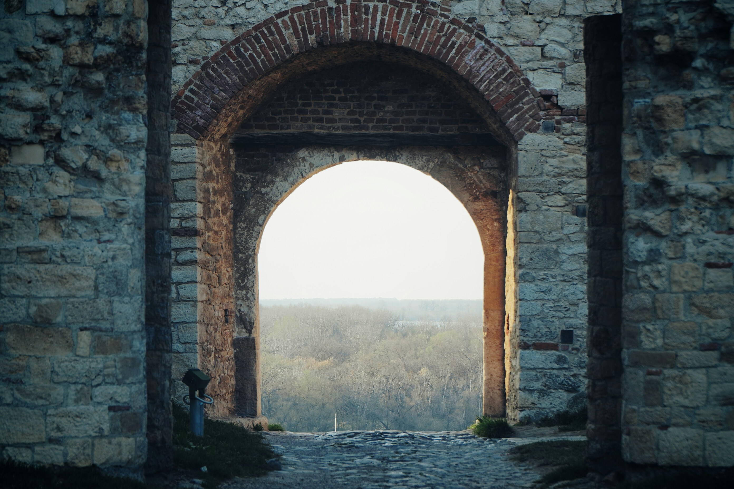 Traveler walking through a massive medieval city gate