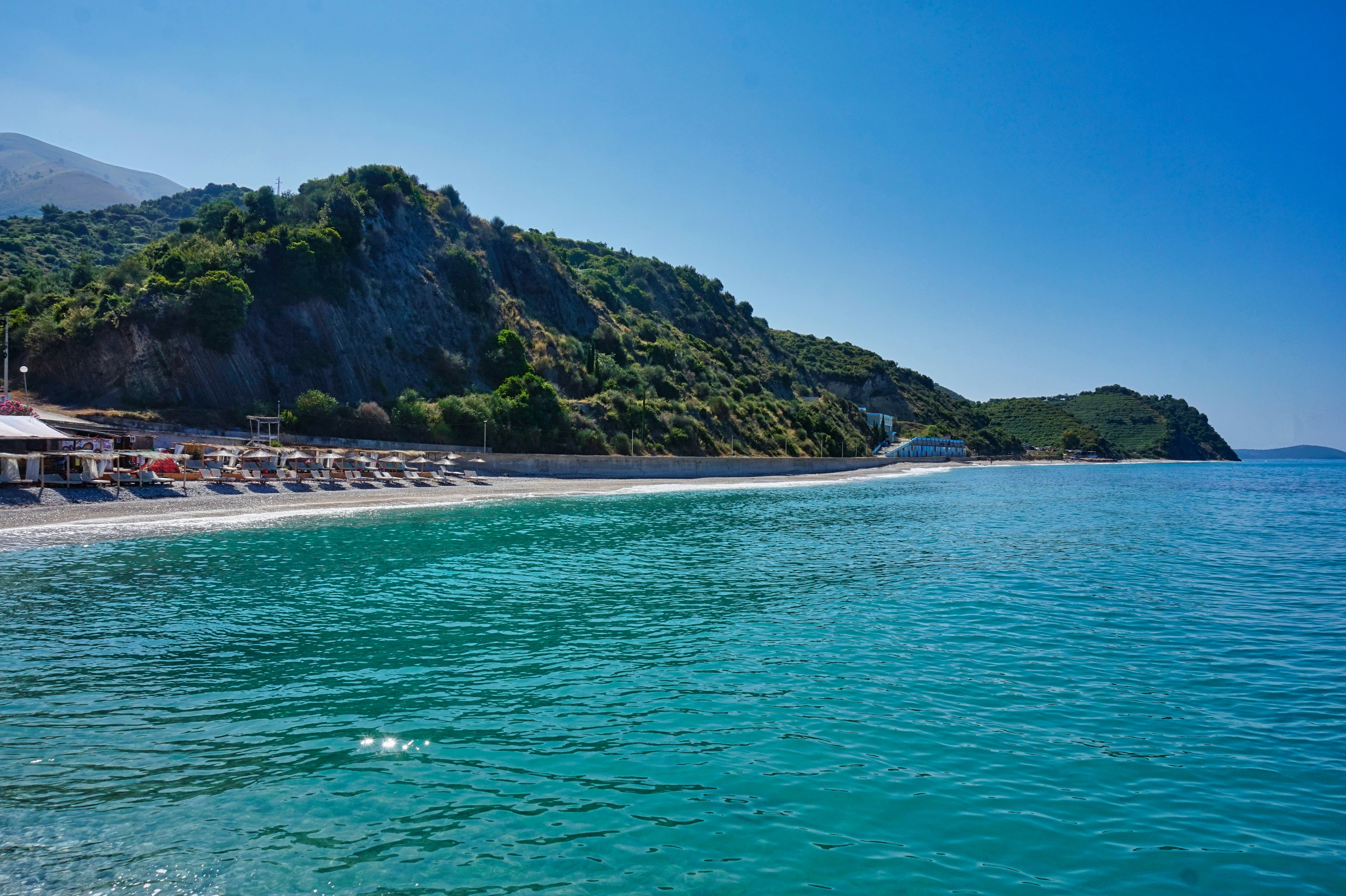 Vista panorâmica da costa da Riviera Albanesa com águas azul-turquesa e aldeias nas falésias.