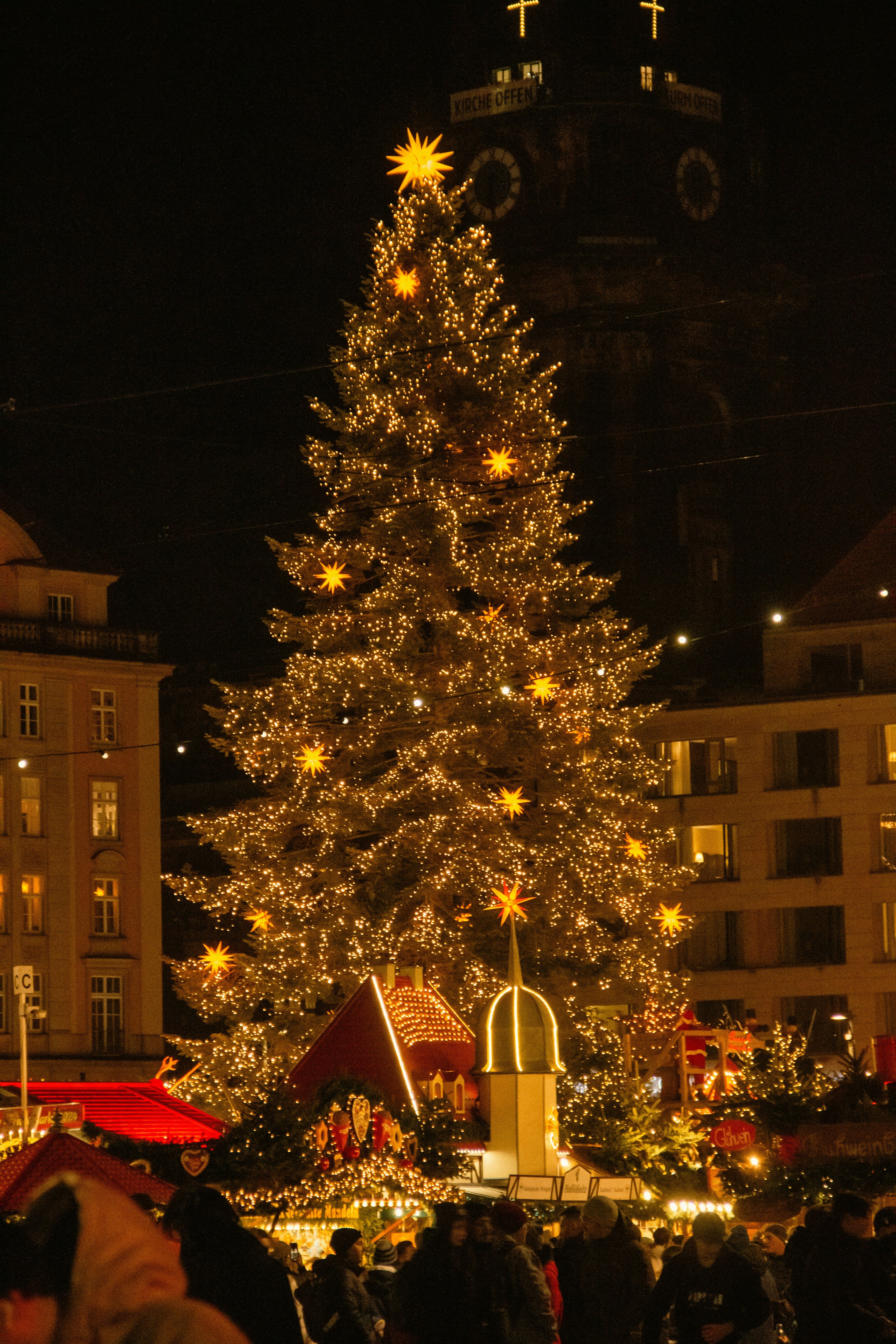 A imponente pirâmide de Natal Erzgebirge no Striezelmarkt de Dresden, iluminada e decorada com figuras de madeira