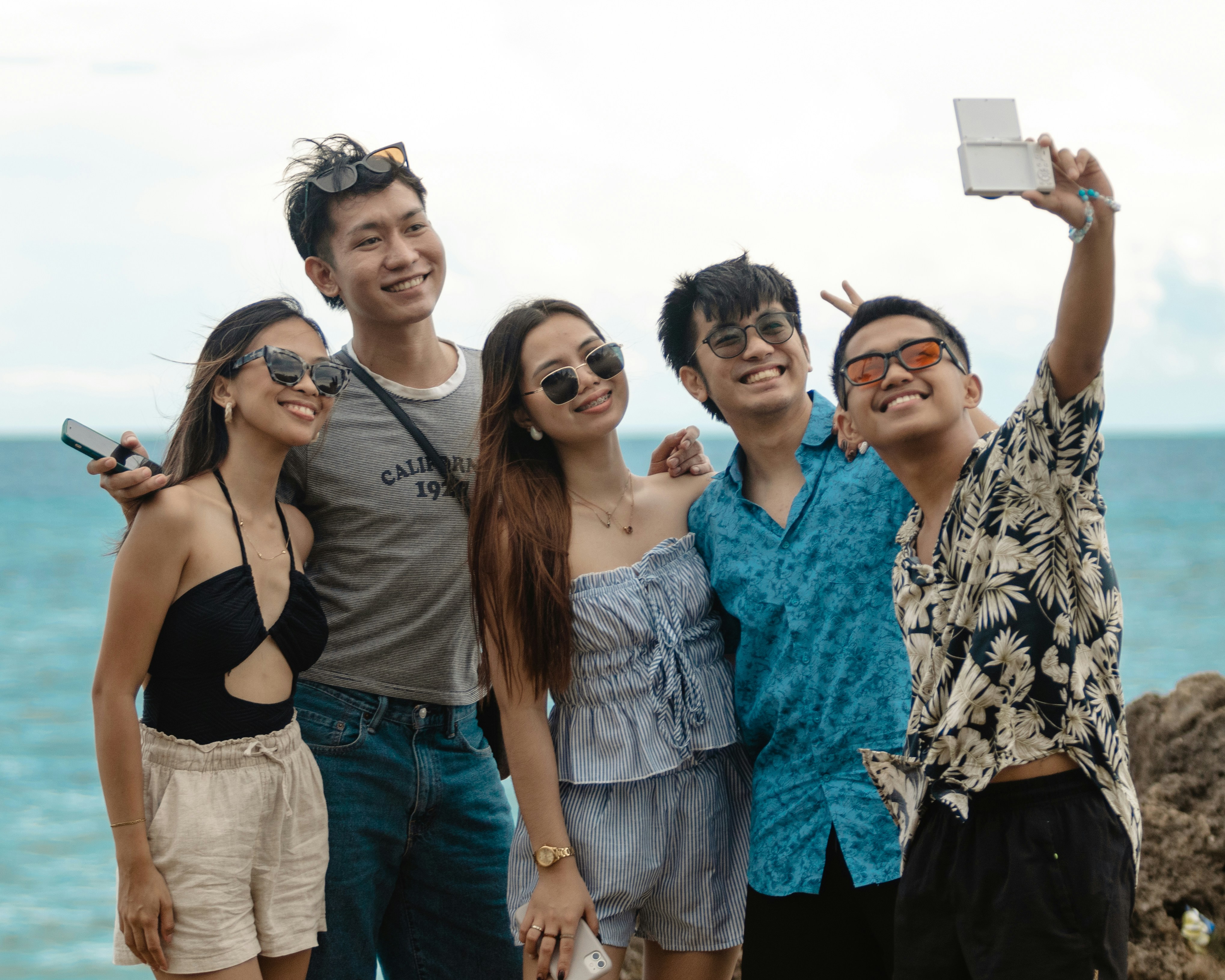 Grupo de amigos a rir enquanto consultam o itinerário de viagem num dispositivo móvel.