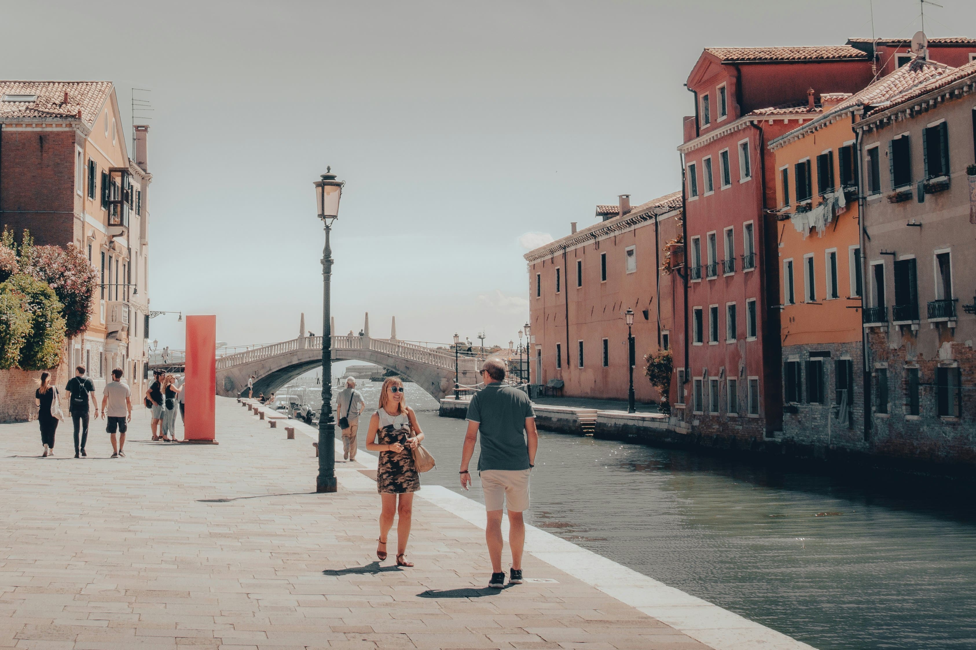 Casal sentado à beira do Grand Canal em Veneza ao pôr do sol