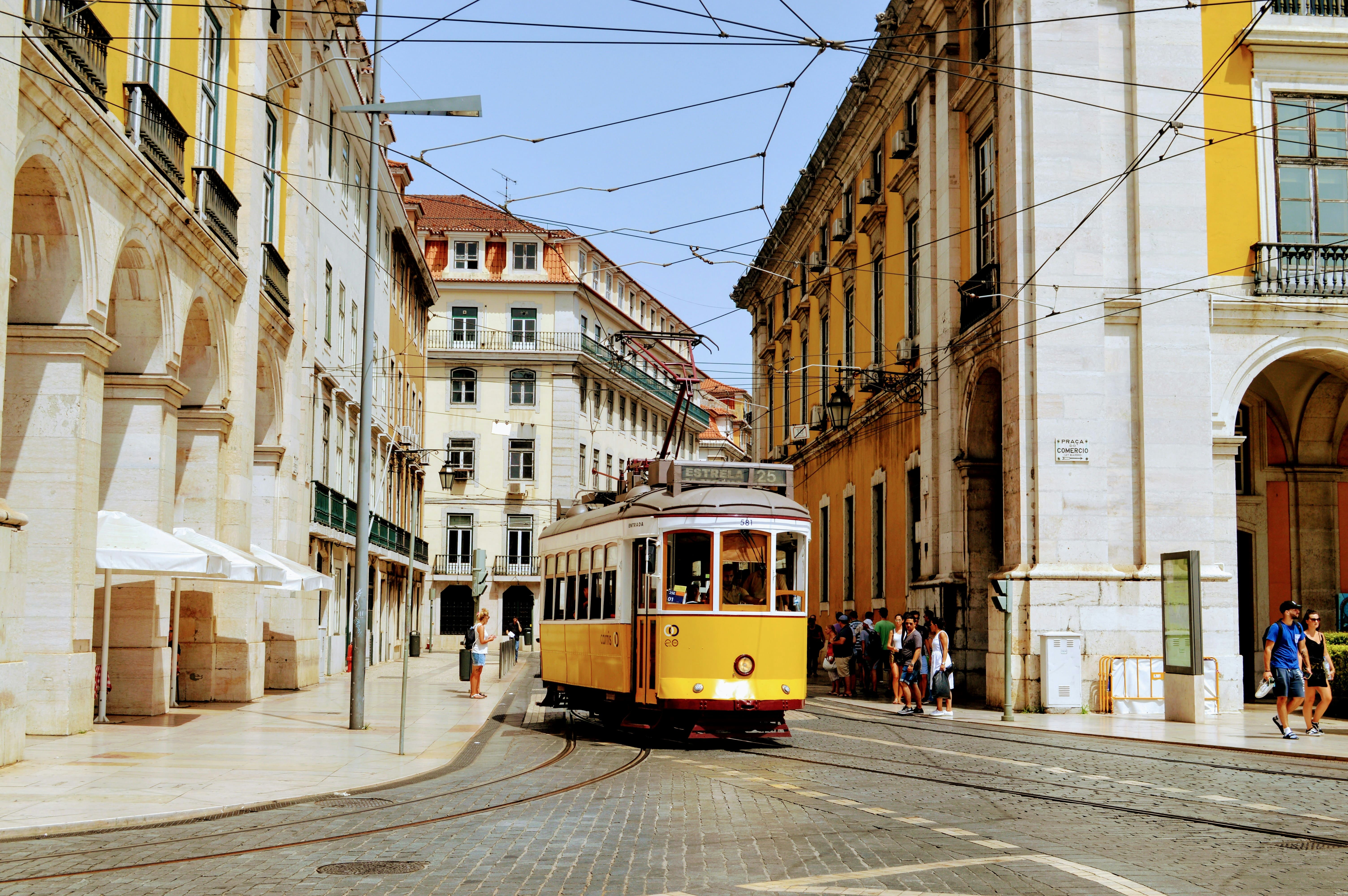 Iconic yellow Tram 28 passing through Lisbon streets