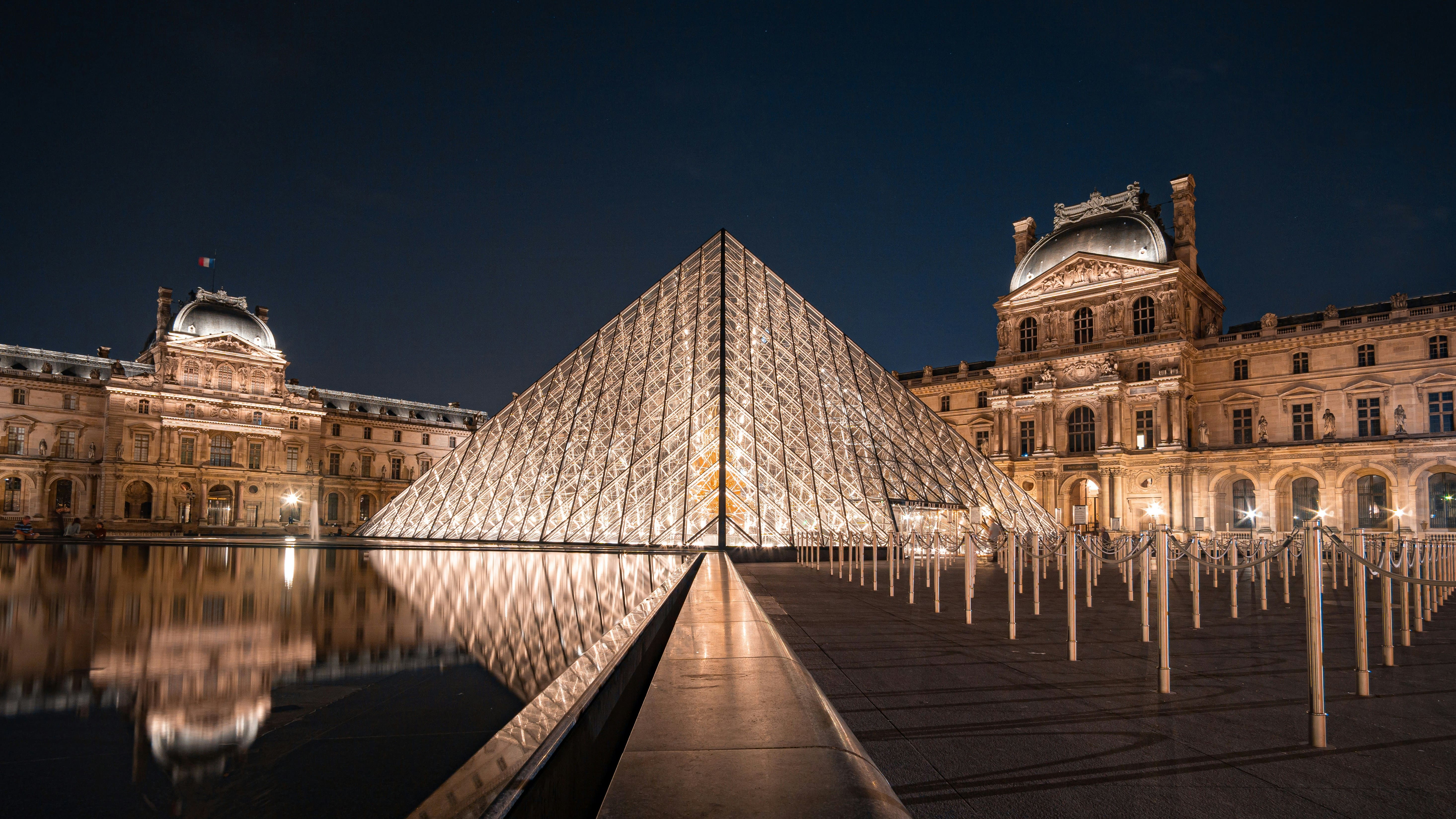 Família no exterior do Museu do Louvre em Paris com pirâmide ao fundo