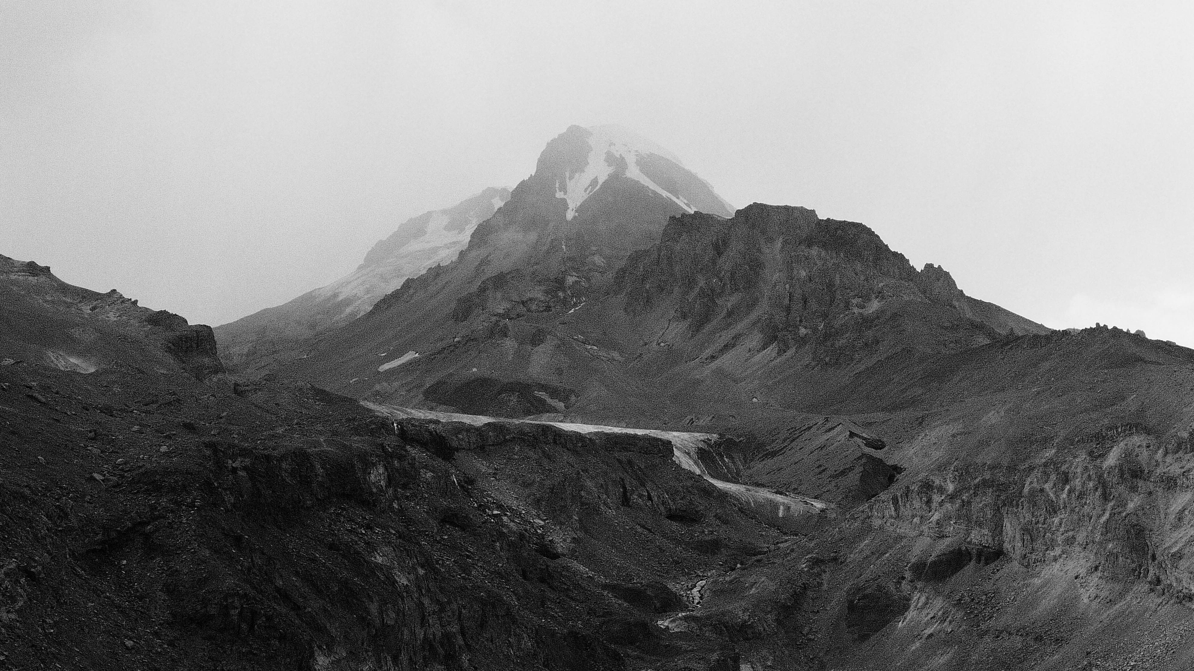 Monte Kazbek coberto de neve acima do vale de Kazbegi