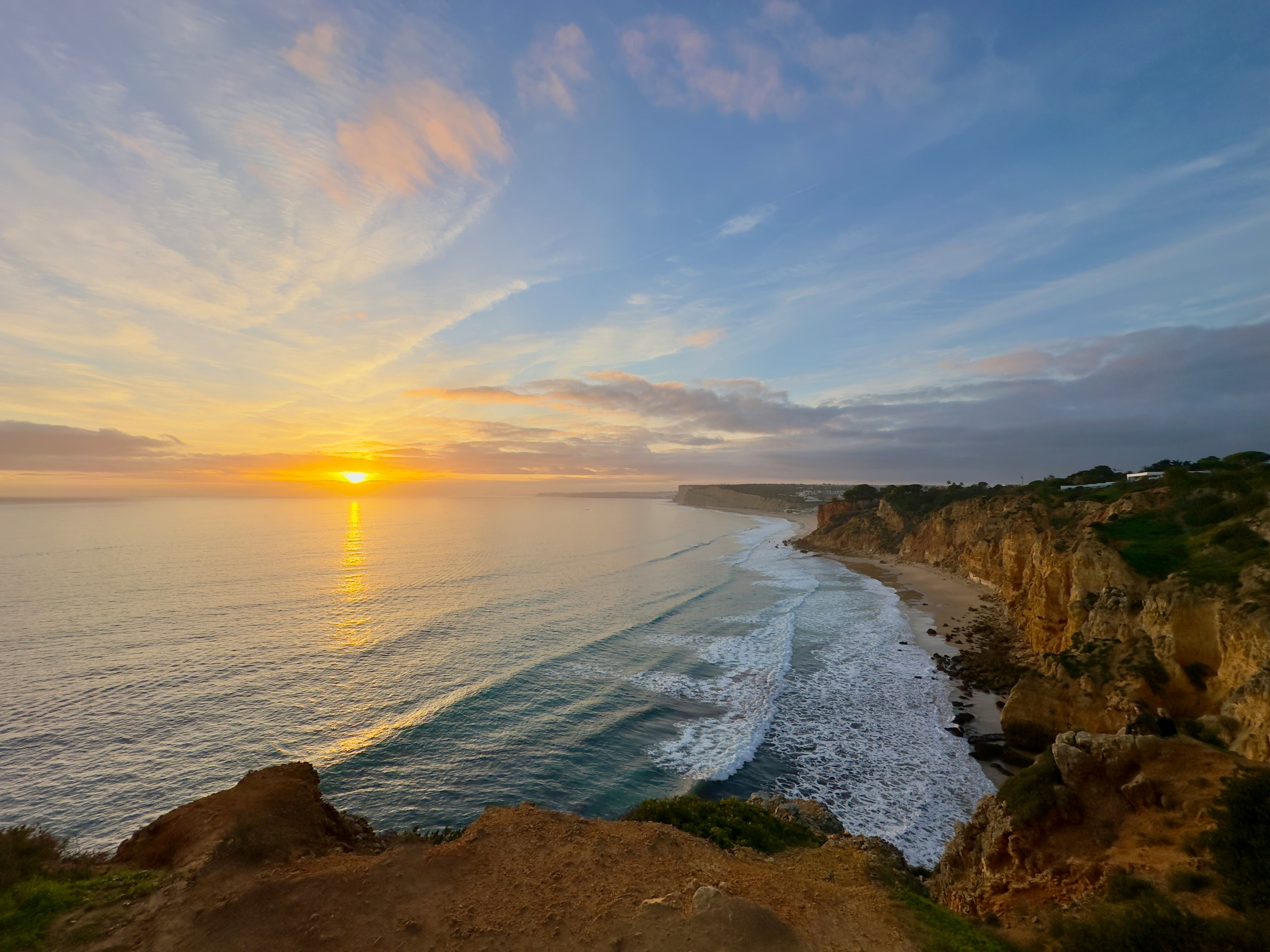 Pôr do sol dourado sobre as falésias de Lagos no Algarve