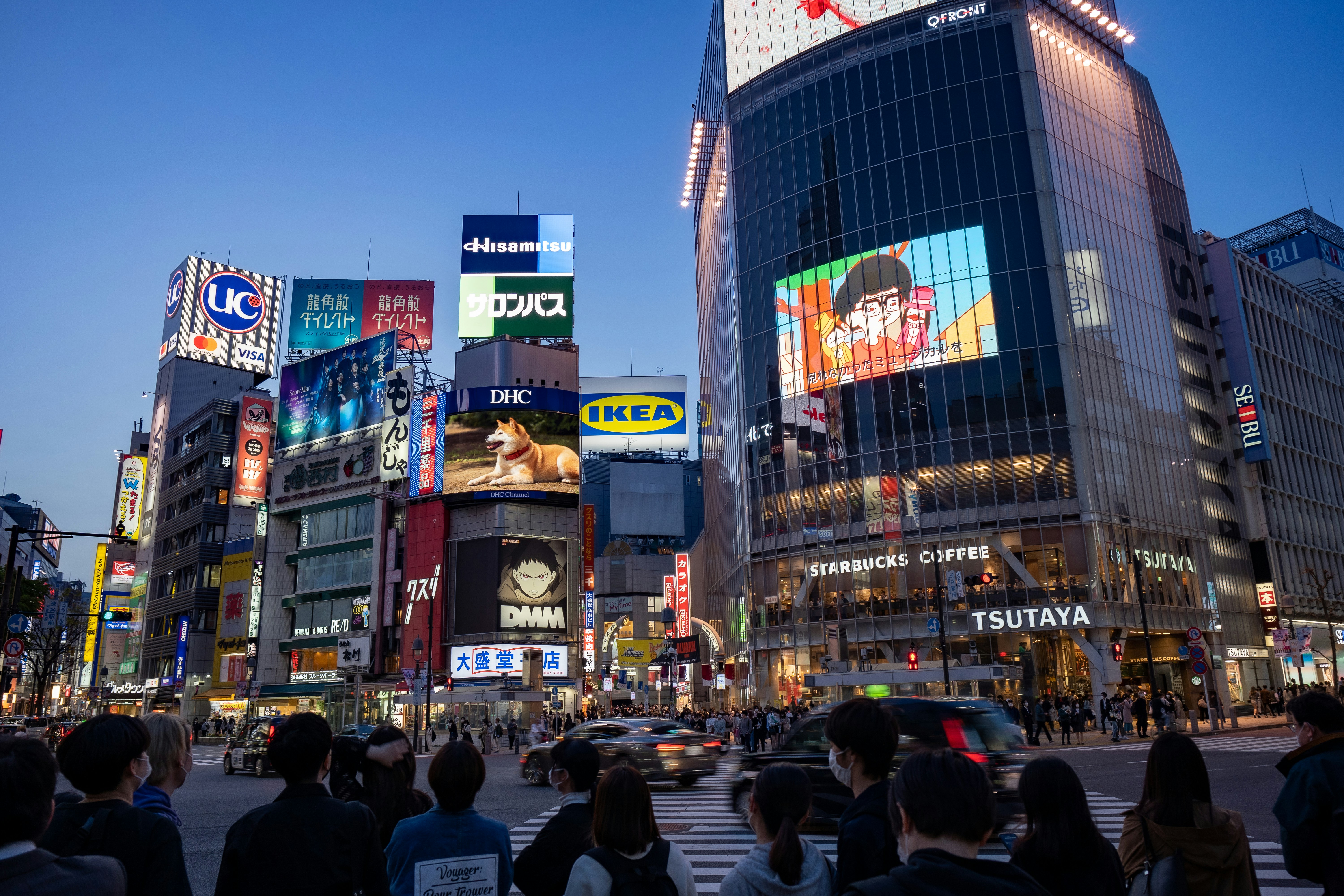O vibrante cruzamento de Shibuya em Tóquio iluminado por neon à noite.