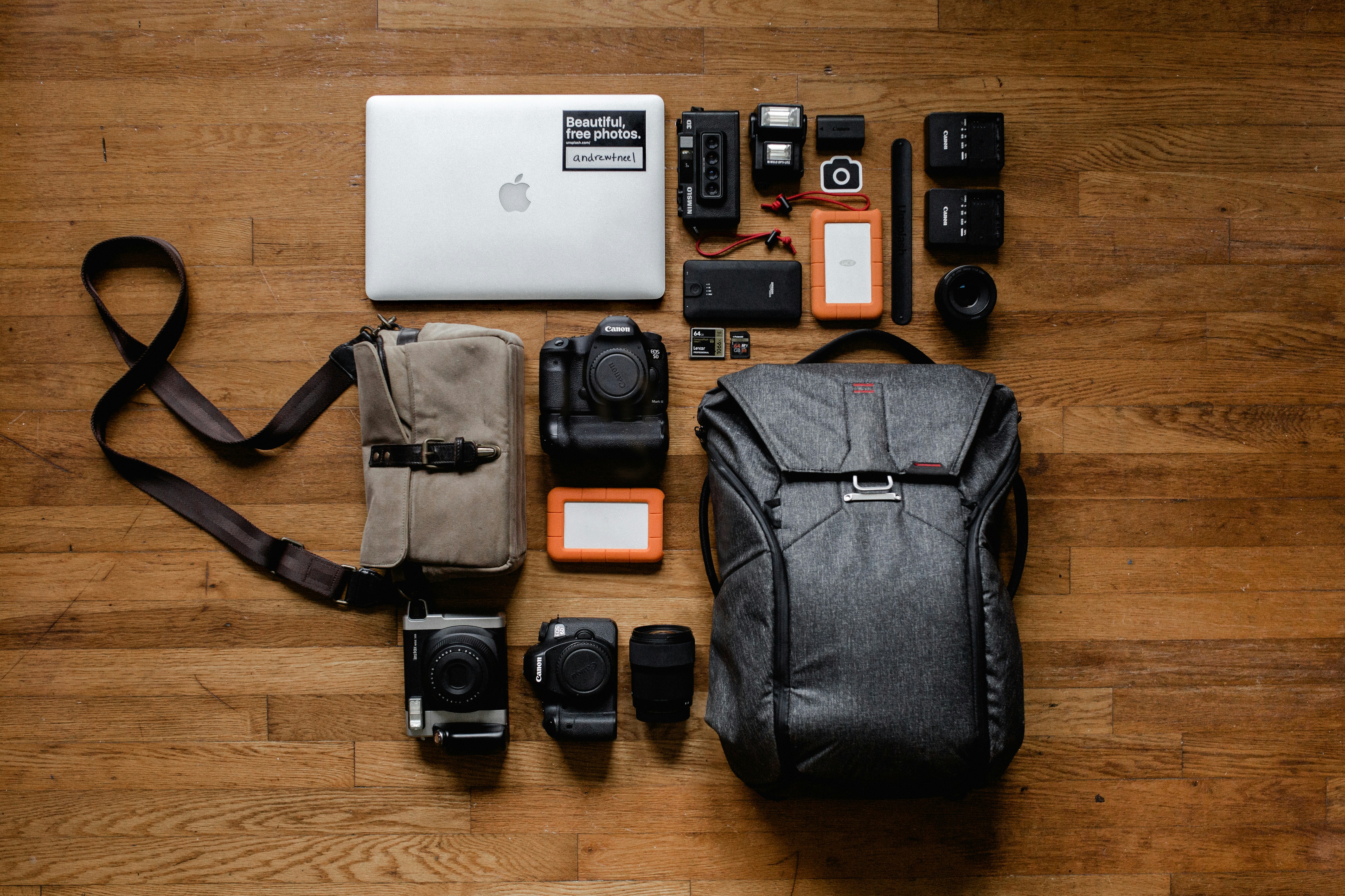 A flat lay of travel tech including a smartphone, power bank, adapter, and headphones