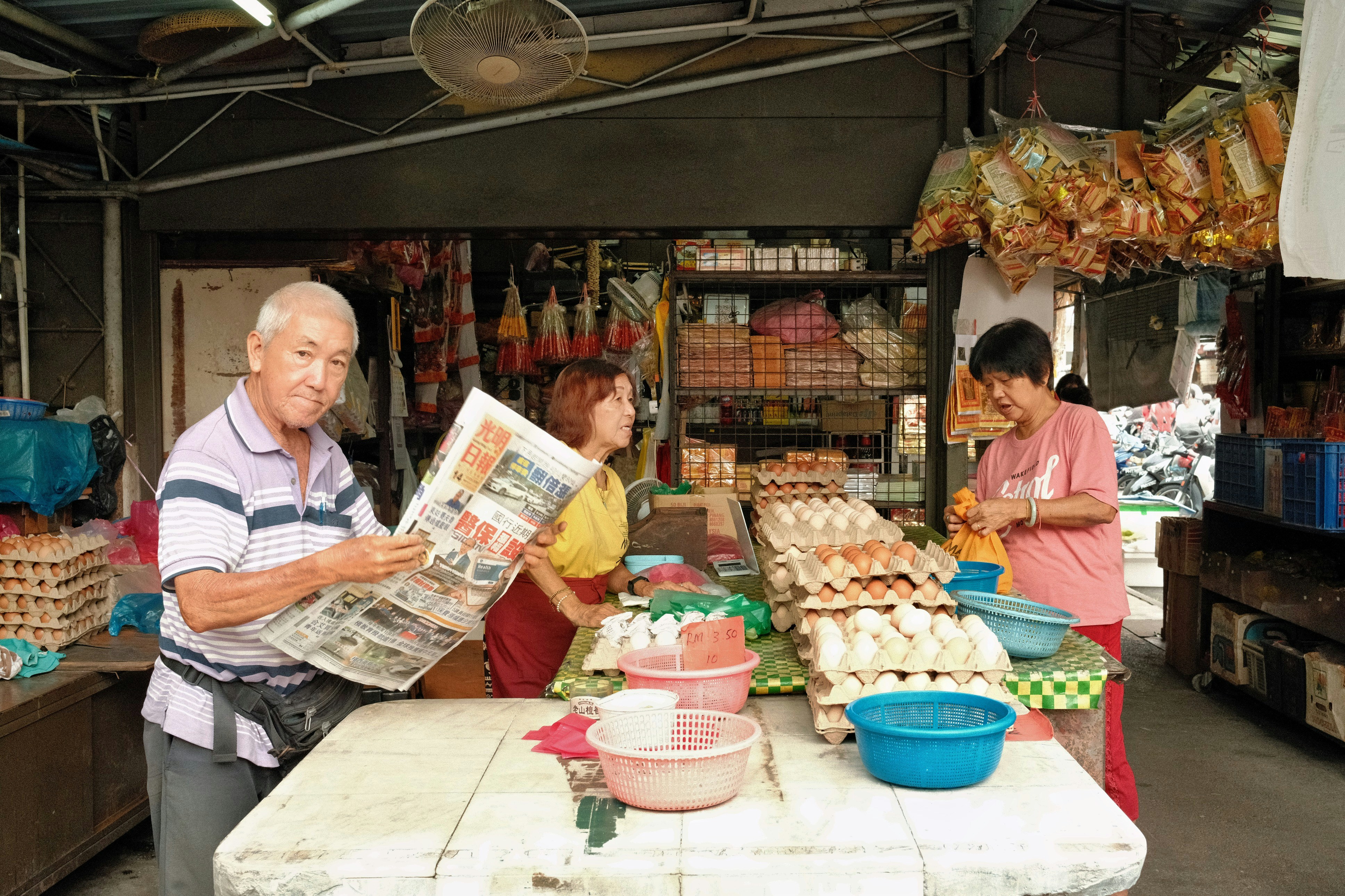 A traveler laughing while interacting with a local vendor at a colorful spice market.